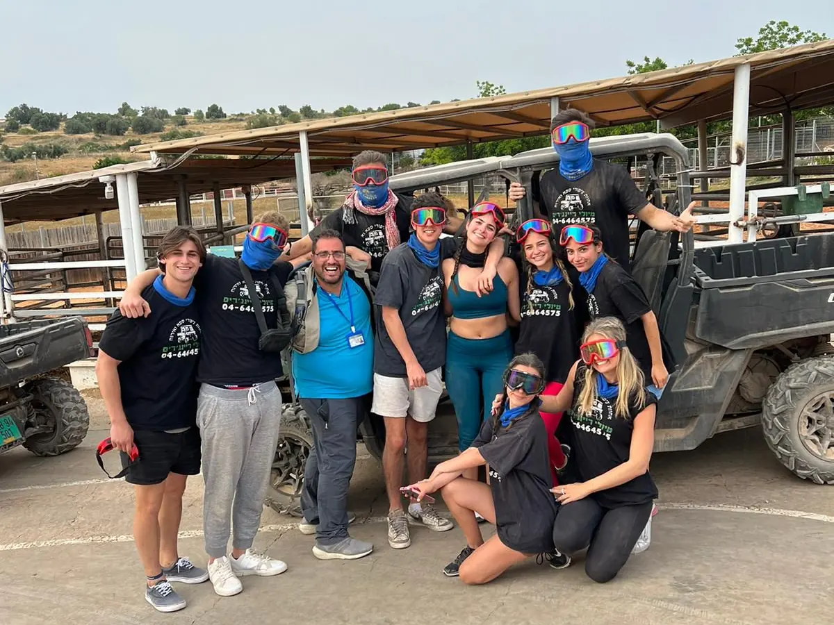 Itzik with travelers beside off-road vehicles in the Negev