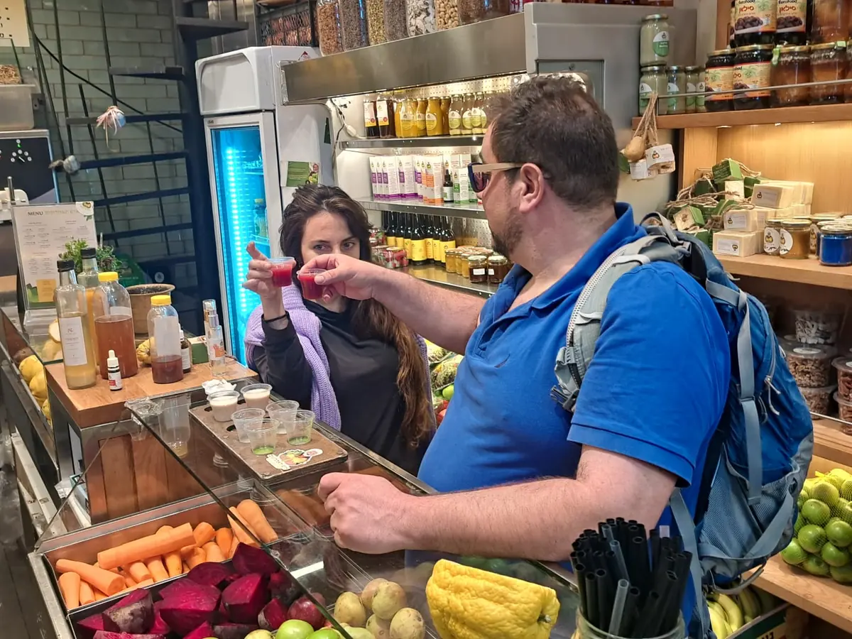 Itzik tasting local food with a traveler at the market