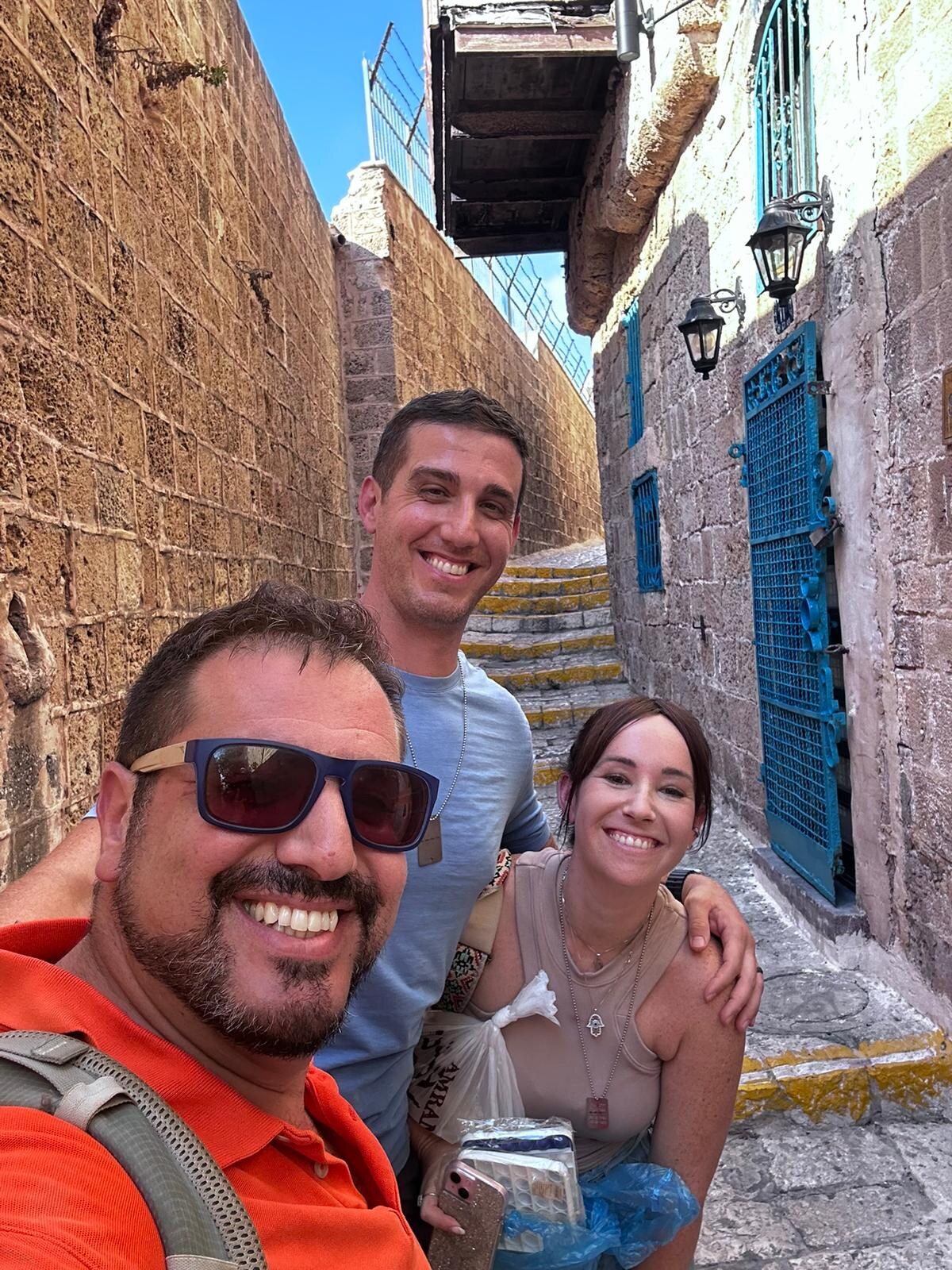 Itzik with travelers in an old stone alley